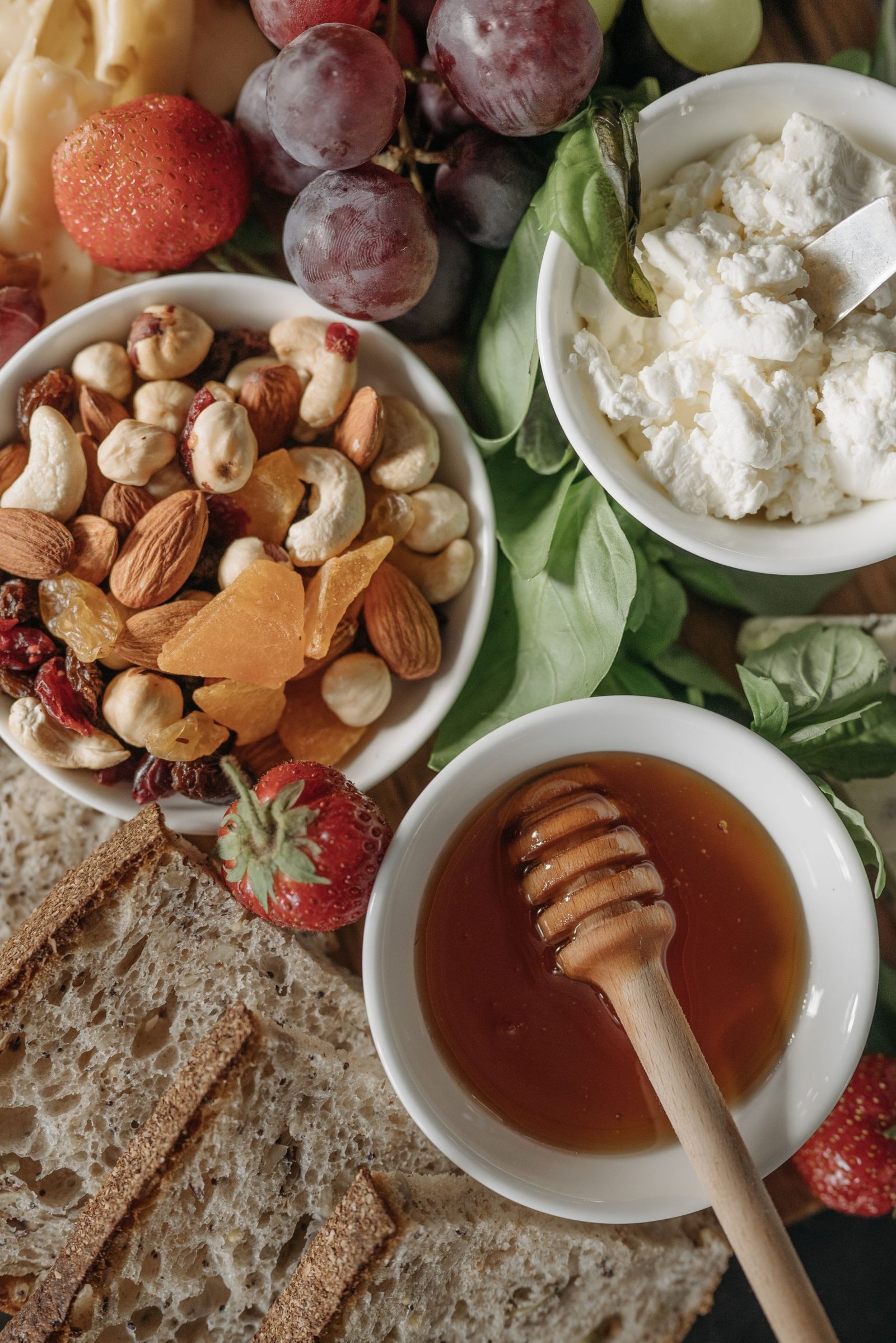 Top view of a nutritious breakfast with assorted nuts, fruits, and honey, styled as a flat lay.